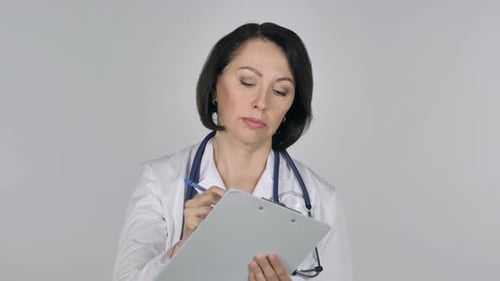 Doctor Writing on Clipboard in Hospital Setting