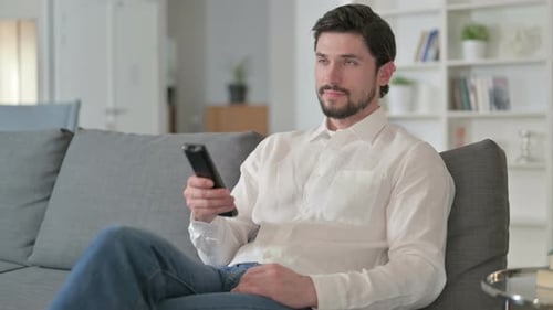Man Relaxing on Couch with Remote Control