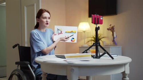 Woman in Wheelchair Presenting Charts on Video Call