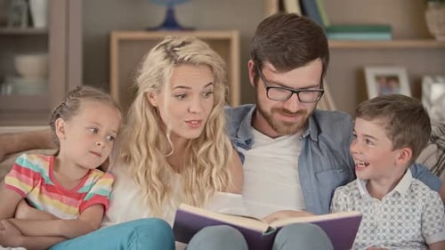 Happy Family Reading a Book Together on Couch