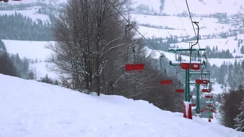 View of the Ski Lift Against the Background of a Mountain Forest and Gray Sky in the Carpathians