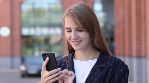 Young Woman Using Smartphone in Urban Setting