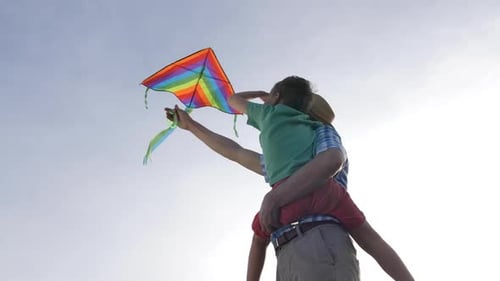 Father and Child Flying a Rainbow Kite