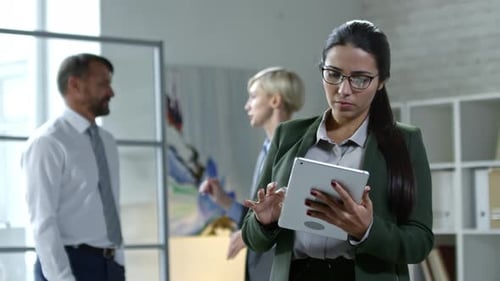 Brünette Geschäftsfrau nutzt Tablet im Büro