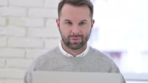 Nahaufnahme eines lächelnden Mannes, der bei der Arbeit in die Kamera blickt