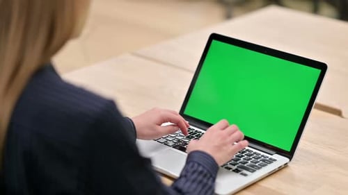 Rear View of Businesswoman Using Laptop with Chroma Screen