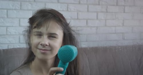 Child Drying Hair with Blue Hairdryer