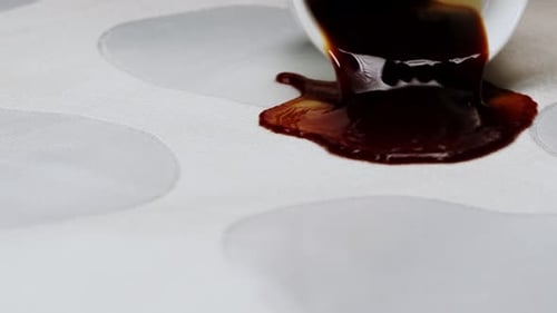 Coffee spills on the table cloth close up shot