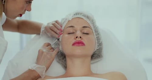 Woman receiving facial injection at medical clinic