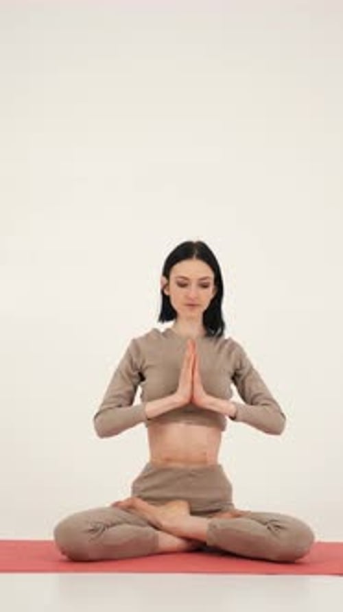 La fille pratique le yoga sur un tapis de gymnastique