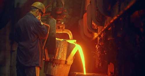 Foundry, a man pours molten metal into the mold