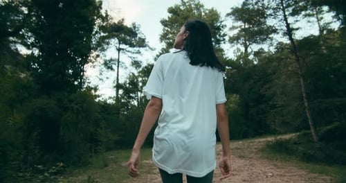 Young Adult Woman From Back Walk in Forest on Summertime Hike Journey