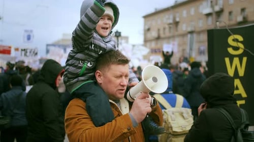 Father and Child Protesting in City Streets