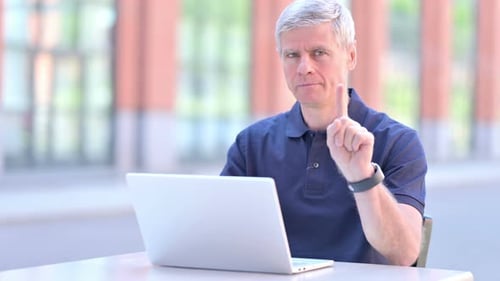 Man Shakes Head No While Working on Laptop