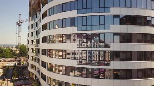 Vista aérea del marco de hormigón de un edificio alto de apartamentos de vidrio en construcción en una ciudad