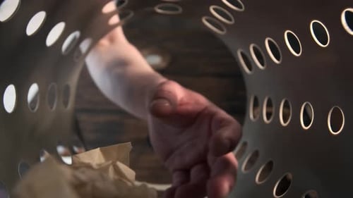 Man Hand Picks Up Abandoned Piece of Paper in Basket Trash Can or Bin
