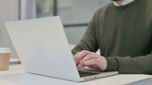 Close Up of Young Businessman Typing on Laptop