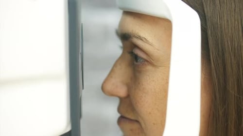 Nahaufnahme Porträt einer Frau während des Tests der Refraktometer-Maschine.
