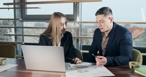 Man and a Woman Discussing Work in the Brightly Lit Modern Office. Concerned Male and Female Working