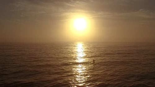 Stand up paddle boarder out early with the sunrise