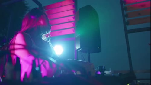 Woman DJ Spinning Music at Night Event