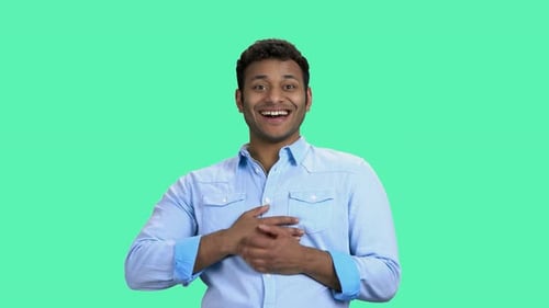 Hübscher indischer Mann lacht auf farbigem Hintergrund