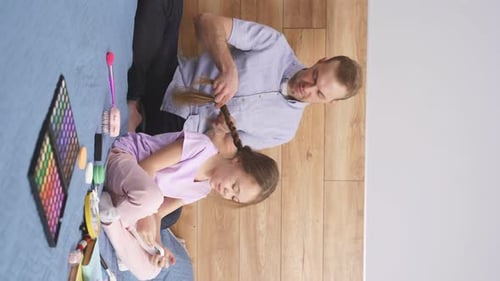 Father Braiding Daughter's Hair at Home