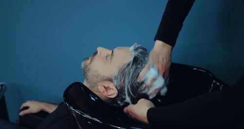Man Receives Shampoo Massage at Modern Hair Salon