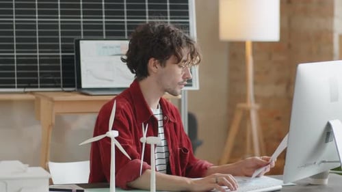 Renewable Energy Engineer Working on Computer in Office