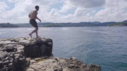 Von einem Felsen springen.