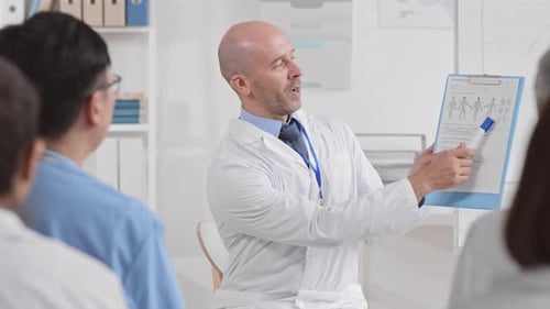 Doctor Leading Medical Seminar with Team in Office