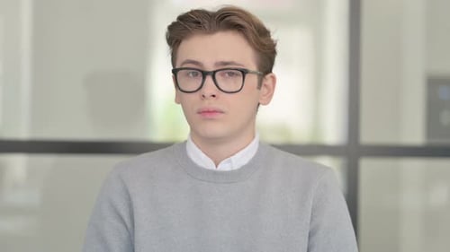 Young Adult Man with Glasses Looks Serious