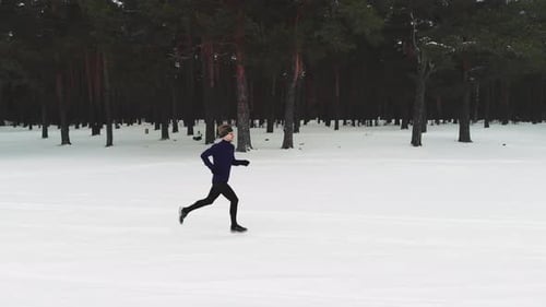 Athletic Person Running Through Snowy Winter Landscape