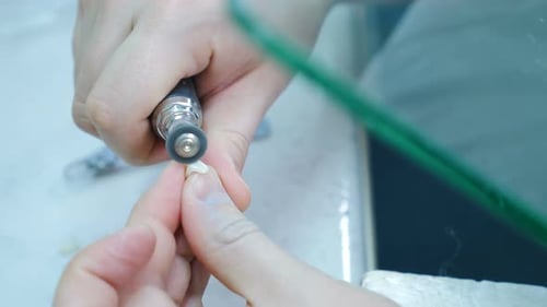 Dental Technician Shaping False Tooth with Tool