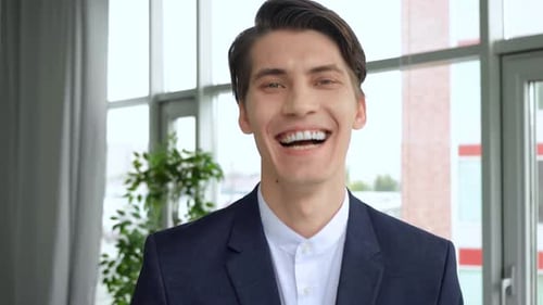 Cheerful guy smiling and looking to camera. 4k Handsome european man with trendy hairdo studio