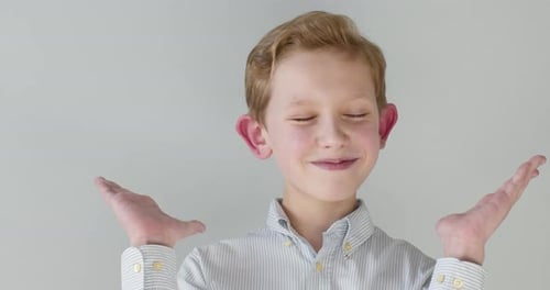 Close-up Portrait. The Boy Is Spreading His Hands and Smiles.