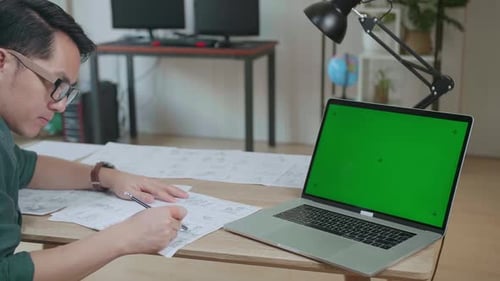 Asian Man Drawing Storyboard Animation Comic Cartoon With Mock Up Green Screen Laptop