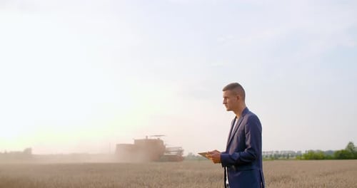Man in Suit Uses Tablet in Wheat Field