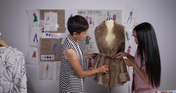 Teacher woman teaching fashion student girl measuring tape on puppet in ...