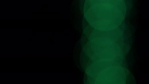 Blurred Green Lights with Bokeh Effect on Black