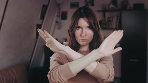 A beautiful girl shows a stop sign with her hands. You shouldn't. The gesture of crossing hands.