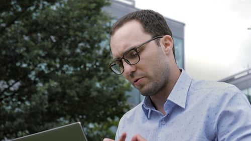 Man Using Laptop in an Urban Setting