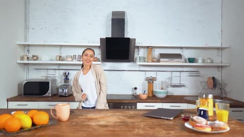 Smiling Woman Dancing in Modern Kitchen