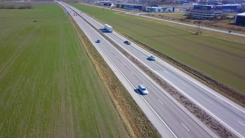 Freeway Road with Moving Cars Between Green Fields