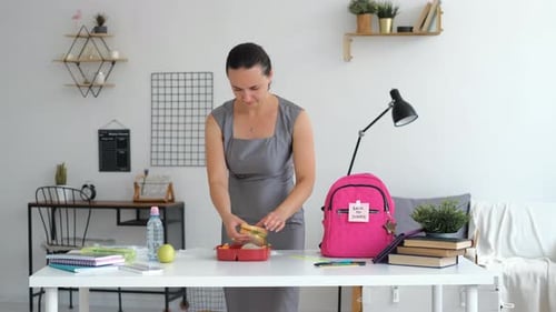 Mother Puts School Lunch in Backpack of Daughter