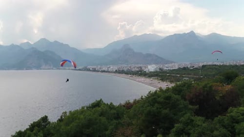 Gleitschirmfliegen über Meer mit Blick Auf Berge Und Grün