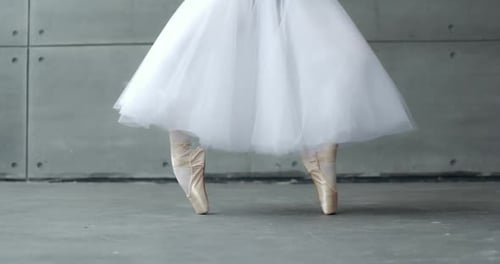 Ralenti, femme dans un tutu blanc, danse, ballet et équilibre, dans des chaussures à pointe, vue des jambes blanches