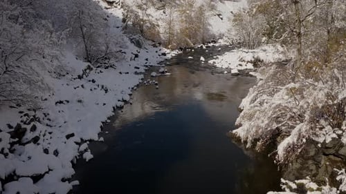 River Flows Through Snowy Winter Landscape