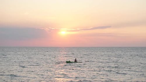 Kayaker Paddles at Sunset on the Sea.
