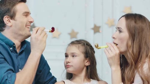 Joyful Family Celebrating with Party Blowers at Home